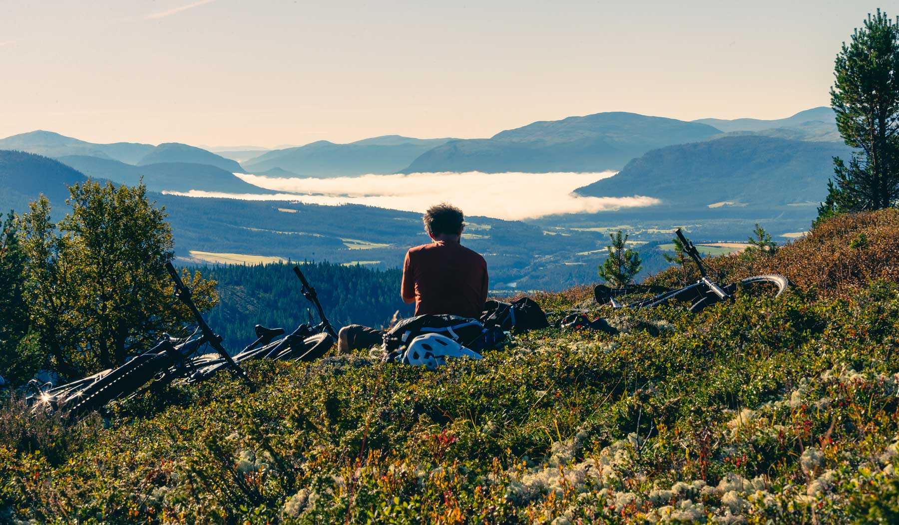 Mountain Biker resting overlooking mountains in Norway